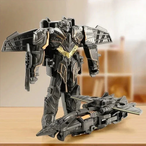 Figurine robot noir et doré de type avion de chasse, posée sur une table en intérieur – Transformers.