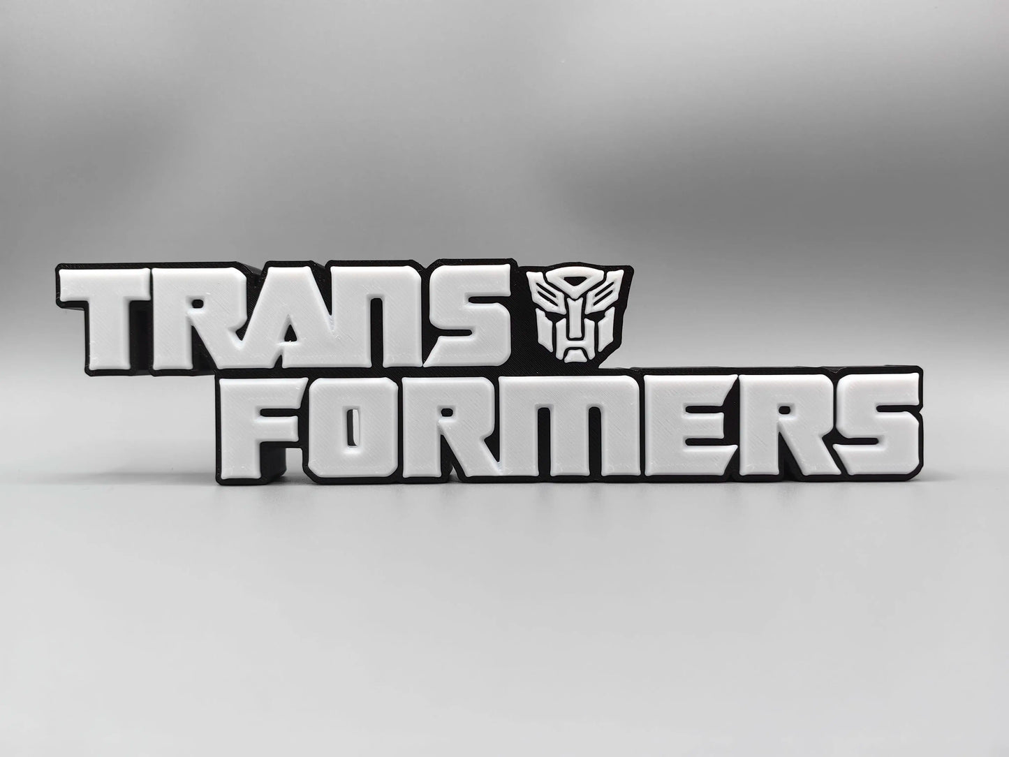 Targa Transformers con logo argentato monocromatico — Decorazione da scrivania con finitura metallizzata