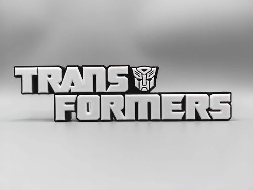 Targa Transformers con logo argentato monocromatico — Decorazione da scrivania con finitura metallizzata