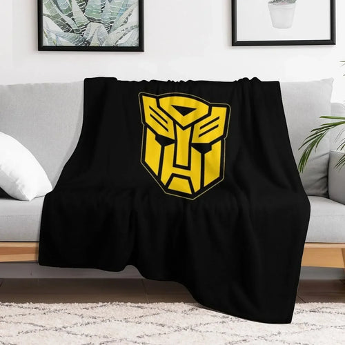 Plaid noir motif logo jaune Autobot sur canapé, déco moderne, style geek – Transformers.
