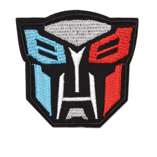 Écusson brodé tête Autobot stylisée, couleurs bleu, rouge, gris sur fond noir – Transformers.