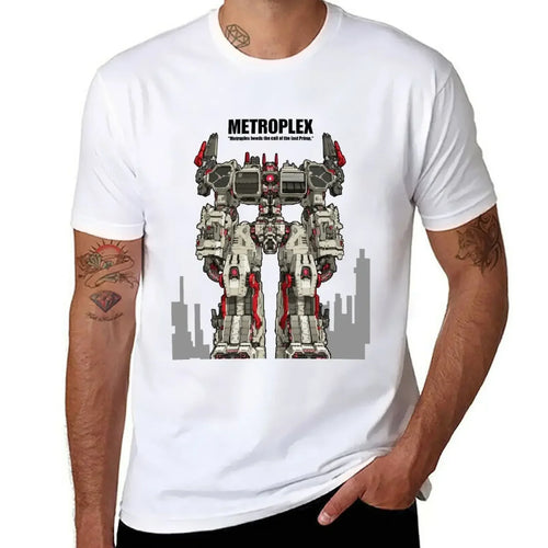 T-shirt blanc avec impression du robot Metroplex debout, décor urbain en fond, style comics – Transformers.
